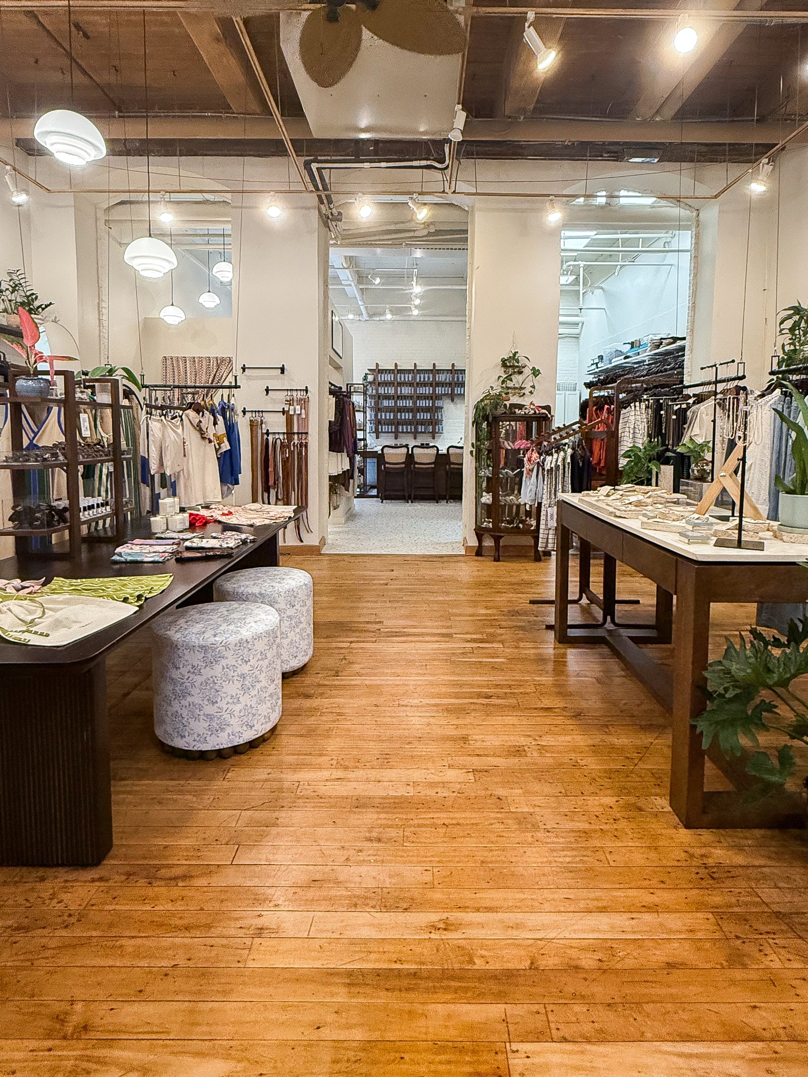 Interior of a clothing store with wooden floors and various clothing items on display. Interior of a clothing store with wooden floors and various clothing items on display.