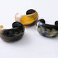 Noonday carved horn cuffs showing natural color variation