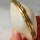 Mini clam shell trinket box with brass clasp, held in hand
